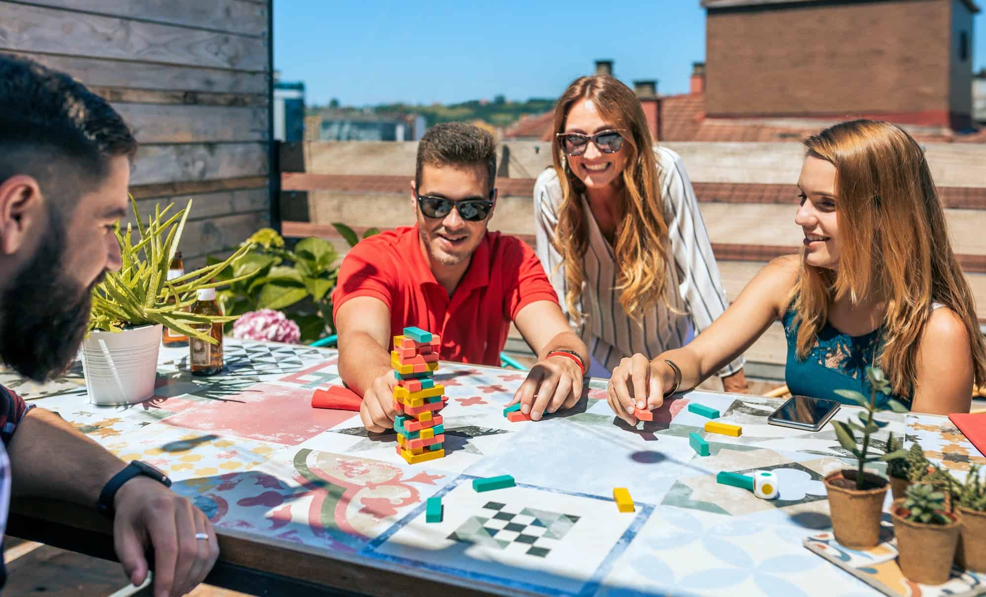 Group of office workers playing with jenga game on terrace