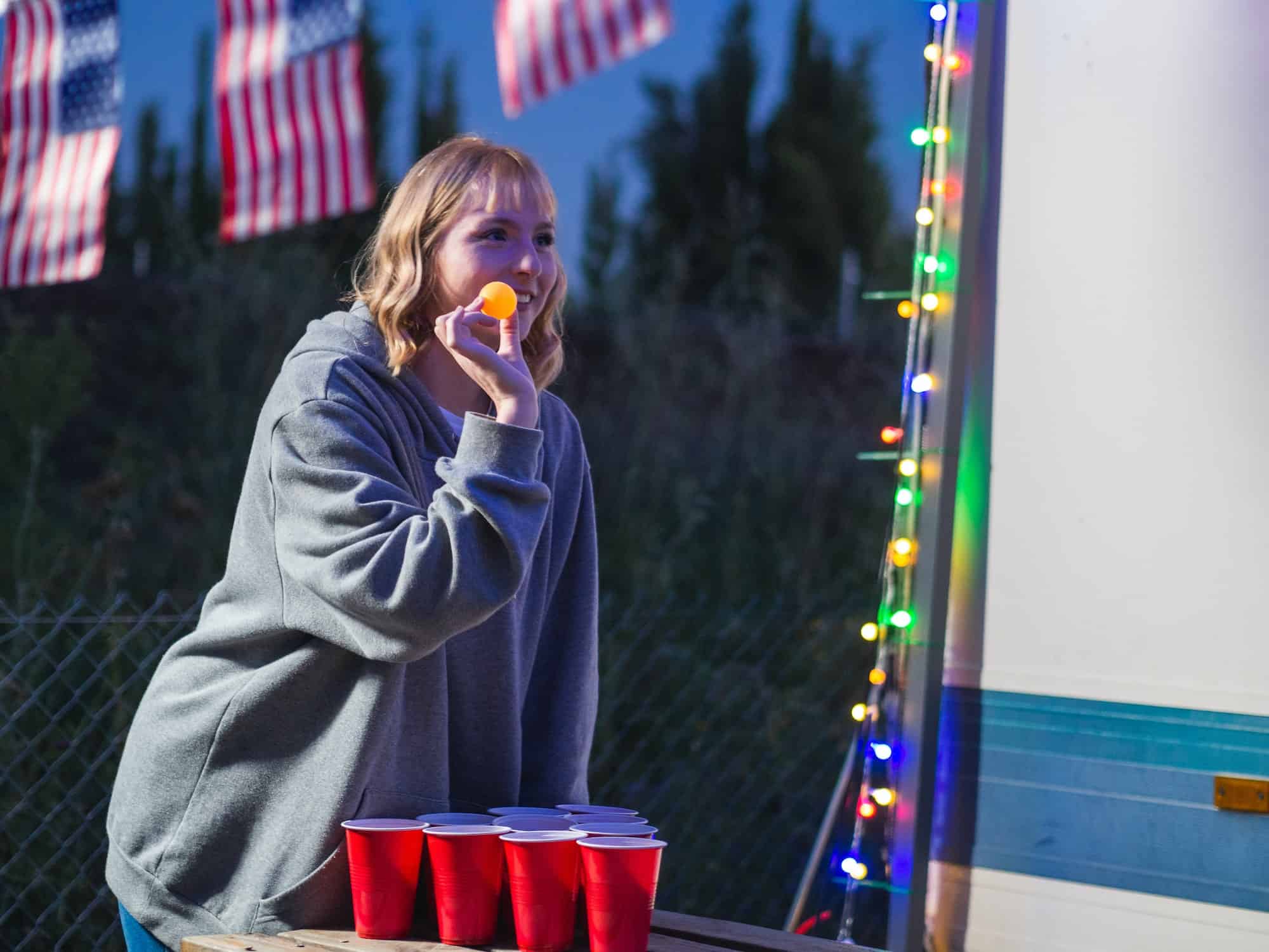 Young blonde female playing beer pong